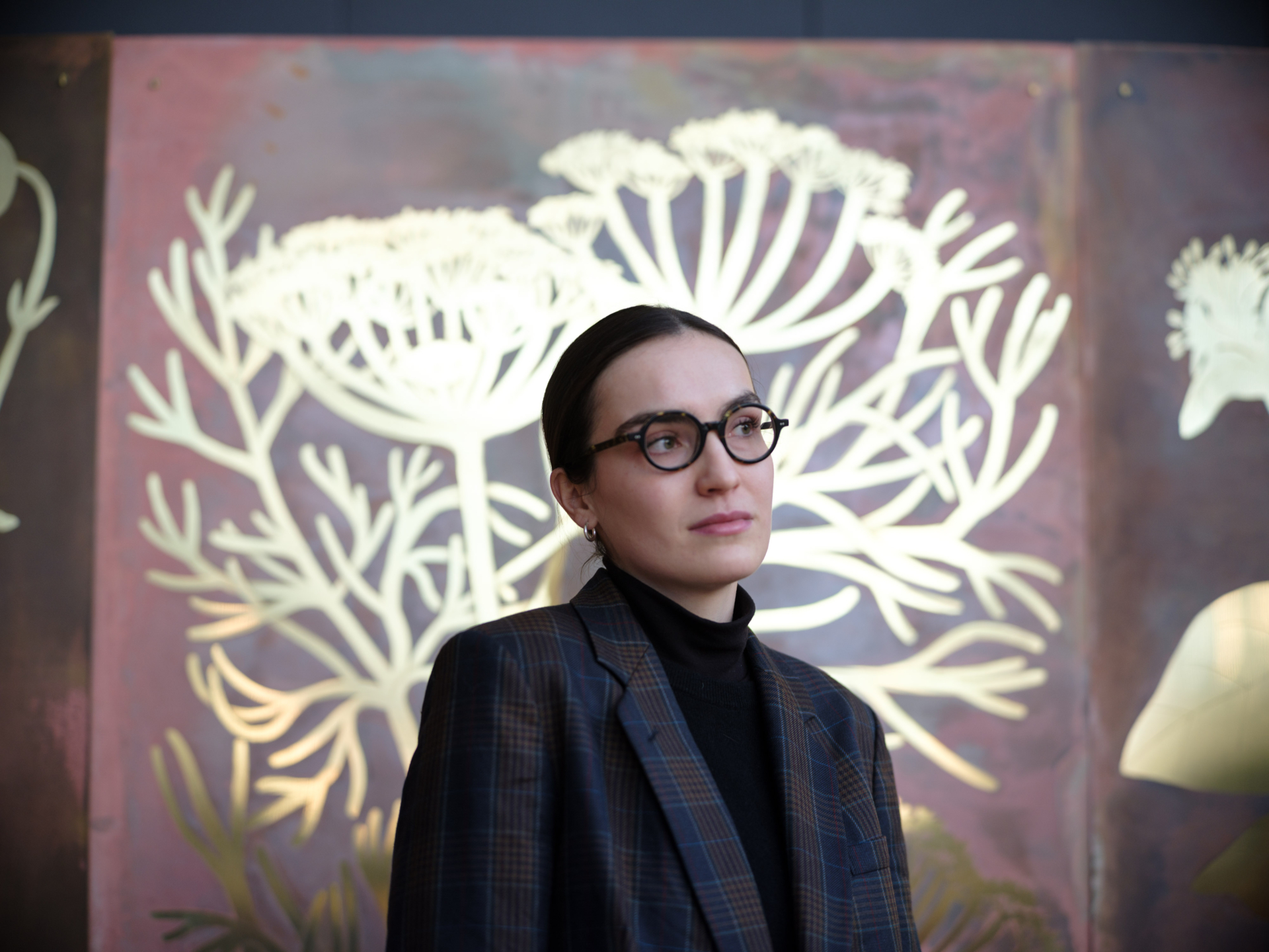 artist alicja biala posing in front of her artistic piece