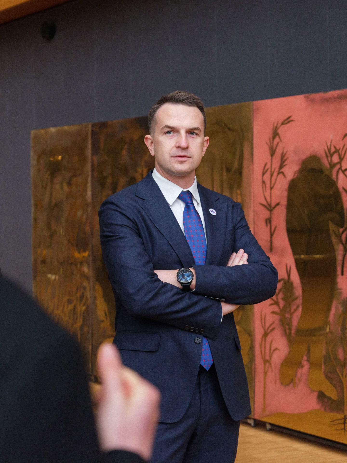 Minister Adam Szłapka in front of art piece by Alicja Biała