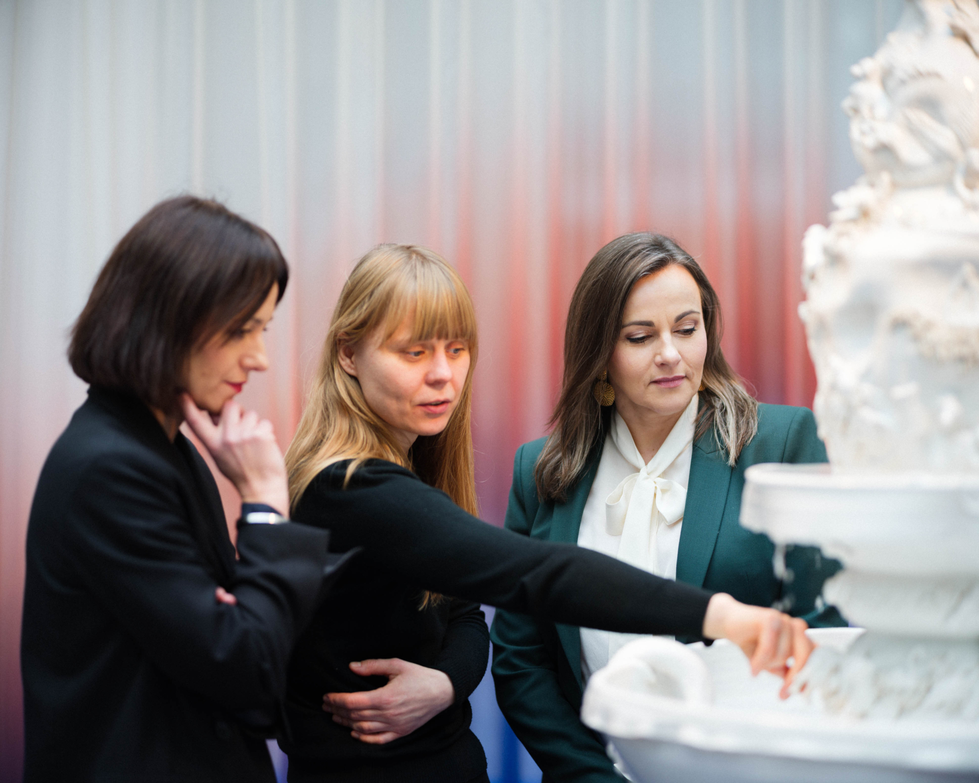women watching a piece of art